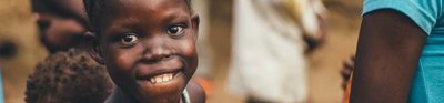 A group of Africa children looking to camera. One girl is focused on particularly and she is smiling