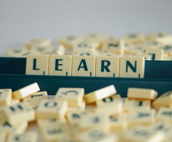 Scrabble tiles on a stand spelling out the word 'learn'