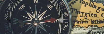 A black compass pointing east, placed on a yellow 'old style' map background