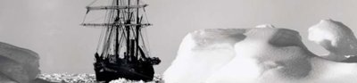 A black boat can be seen stuck within the white ice backdrop. The ice is undulating and tinged grey by shadows