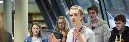 Person giving a talk to students in the reading room of the Society