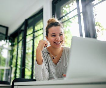 Female watching a lecture recording on their laptop. 