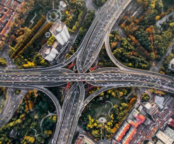 Birds eye view of intersecting highways above a park