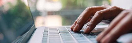 Closeup image of a woman working and typing on laptop computer keyboard