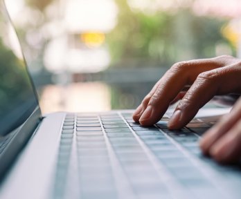 Closeup image of a woman working and typing on laptop computer keyboard