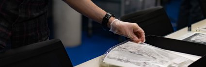 A researcher wearing archival gloves viewing historic photographs in a folder