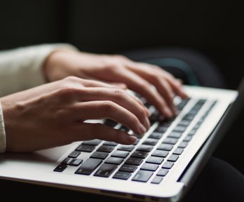 A person typing on a laptop