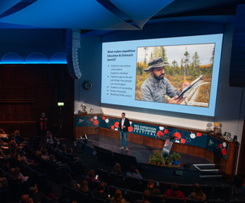 Speaker Tim Jacobs stood on stage in the Ondaatje Theatre at Explore 2022.  