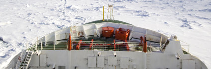 Looking out to the front of the SA Agulhas II ship sailing through the ocean in Antarctica, with pack ice all around