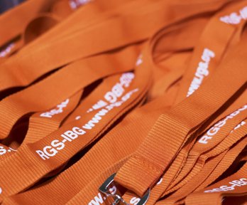 Orange conference lanyards with white lettering reading RGS-IBG