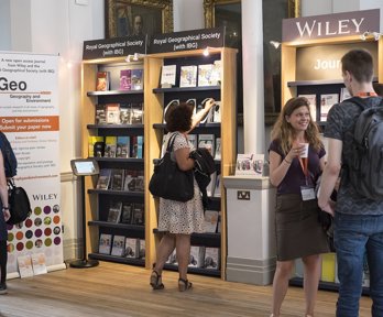 Conference delegates standing in front of shelves of books and journals