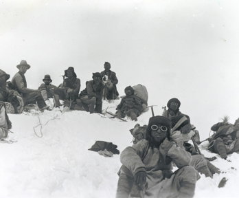 Historic black and white photograph of Sherpa climbers with mountaineering equipment on Mount Everest