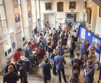 A group of conference delegates networking over tea and coffee